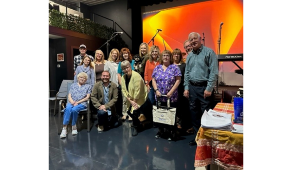 group of people posing in front of a stage