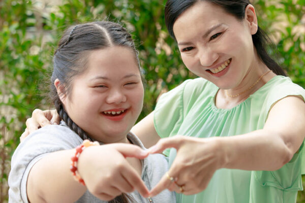 about-us-2 Mother and daughter making a heart with their hands.