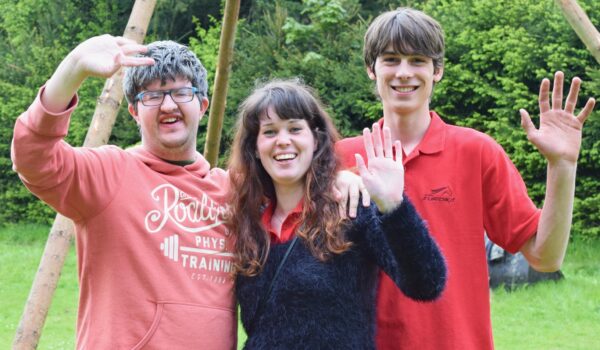Nebeská,Rybná,,Czech,Republic,,13.5.2017,,Day,Of,Smiles,,Beneficent,Charity Three people waving to the camera standing in front of woods.