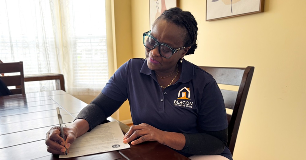 referral-page-admission Woman sitting at a table filling out a form.
