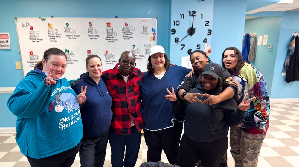 referral-page-group Group of seven people smiling and flashing peace signs at the camera.