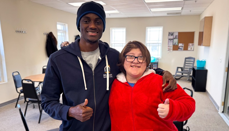 Man and woman at a day program giving the thumbs up sign.