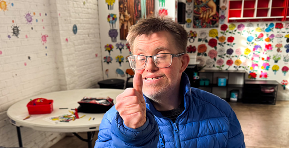 va-behavioral-4 Man giving thumbs up sign in a day program art gallery.